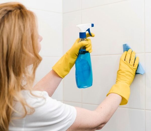 vista-lateral-mujer-limpiando-pared-ducha_23-2148465057